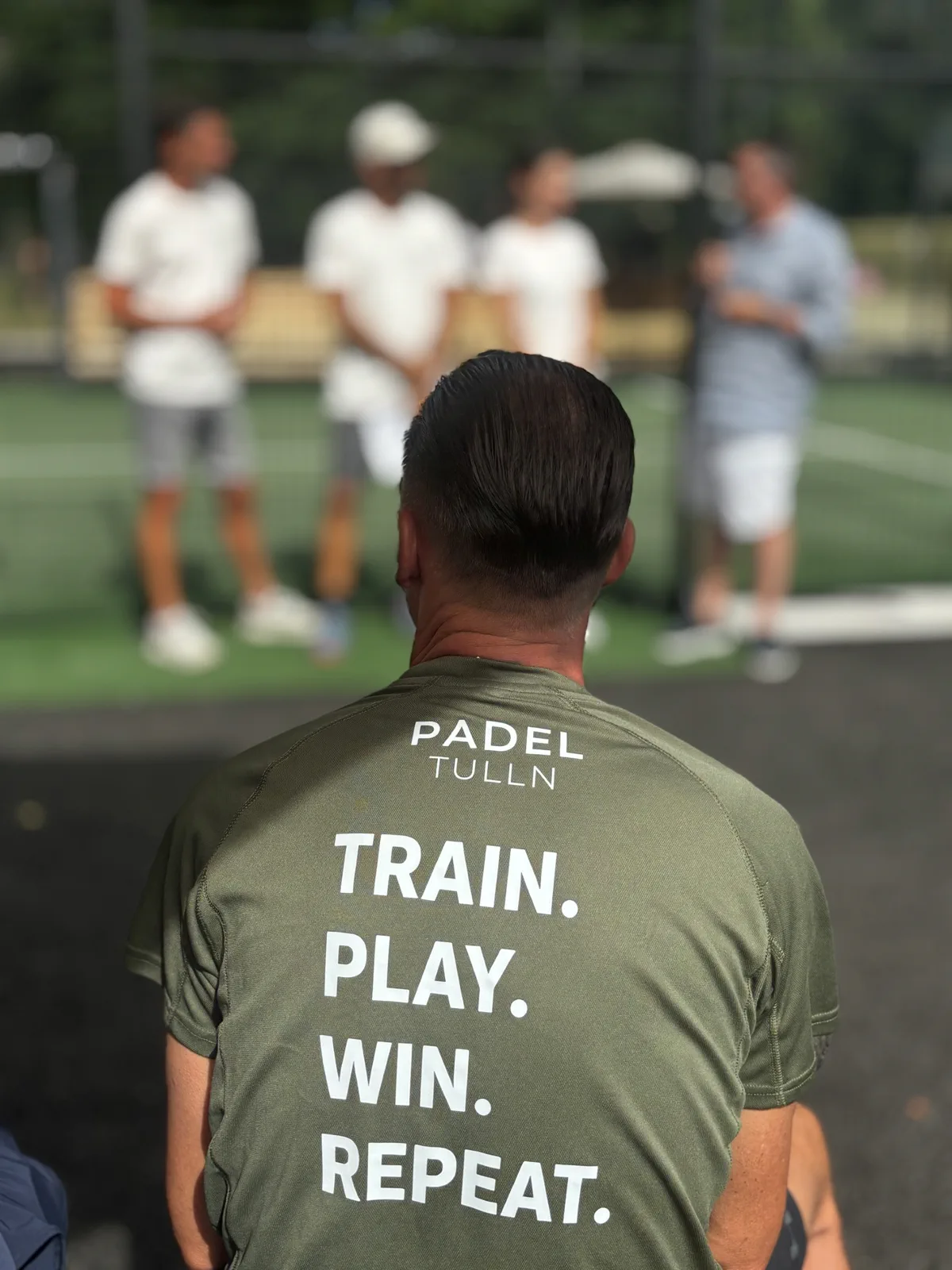 Trainer im Padel-Tulln-Shirt mit dem Aufdruck Train. Play. Win. Repeat.